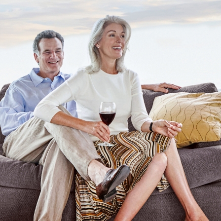 A couple enjoying a glass of wine in their senior living apartment.