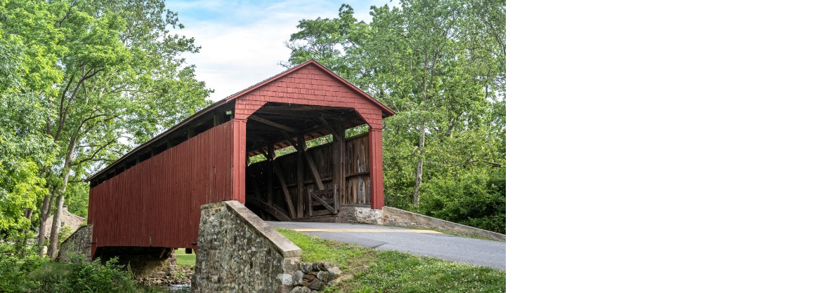 A 55+ continuing care community nestled in the middle of a field, featuring a covered bridge.