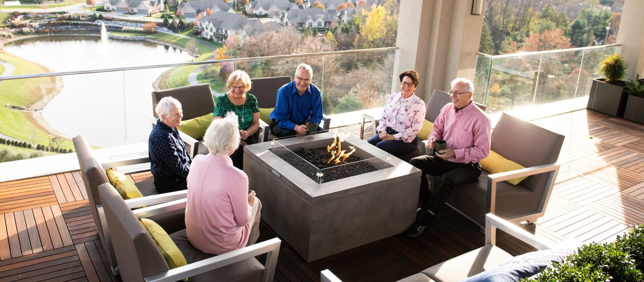 A group of elderly people enjoying independent living by sitting around a fire pit.